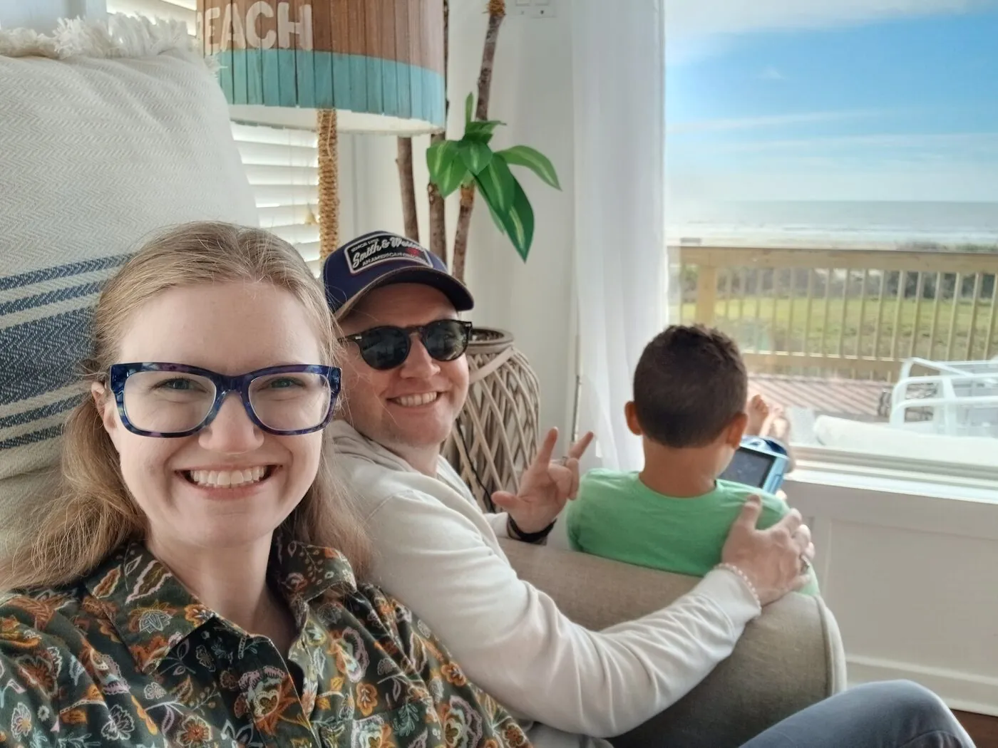 Jared, his wife, and Levi relaxing in a beach house with the ocean out the window